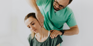 doctor assisting helping a woman with neck pain