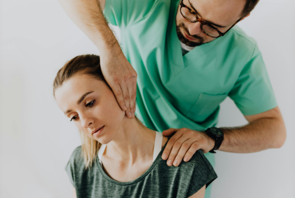 doctor assisting helping a woman with neck pain