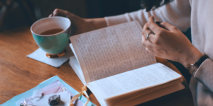 Person reading and writing in a journal