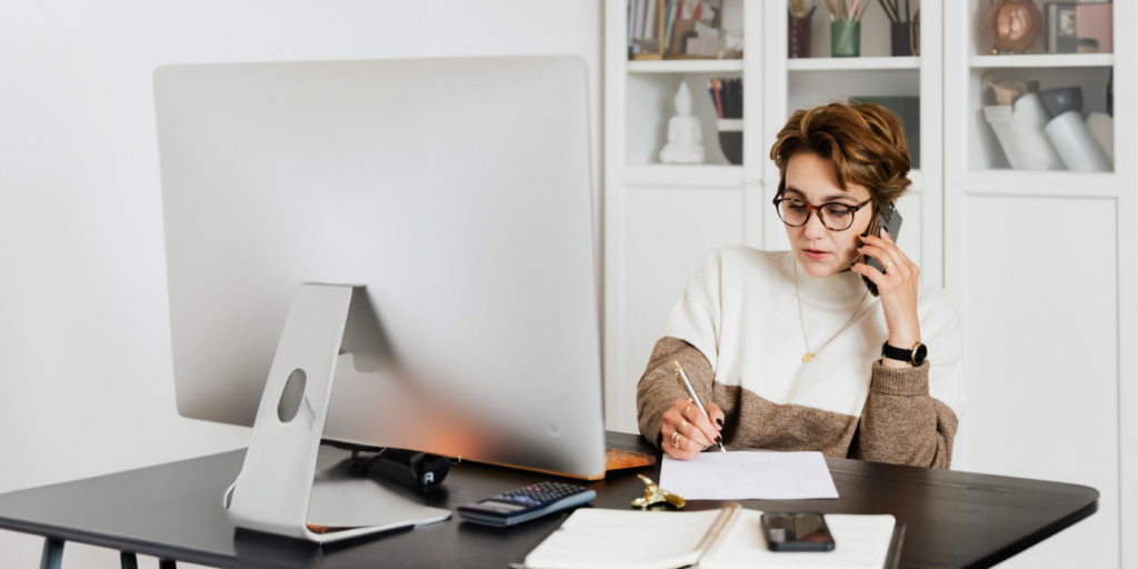 Woman sitting at a desk on the phone. Contact an Attorney