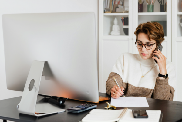 Woman sitting at a desk on the phone. Contact an Attorney