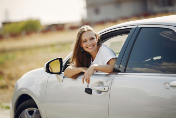 Female teenager sitting in a car holding keys. Teen Driver Safety Week