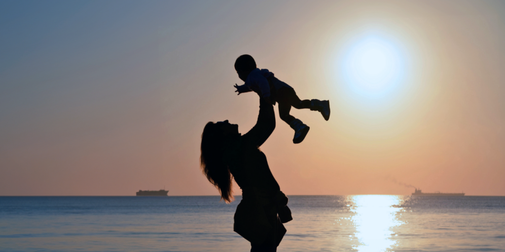 Woman holding a baby up in the air. Bentley's Law