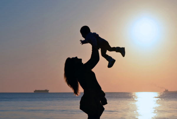 Woman holding a baby up in the air. Bentley's Law