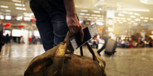 Person holding a suitcase and boarding pass during Christmas holiday season.