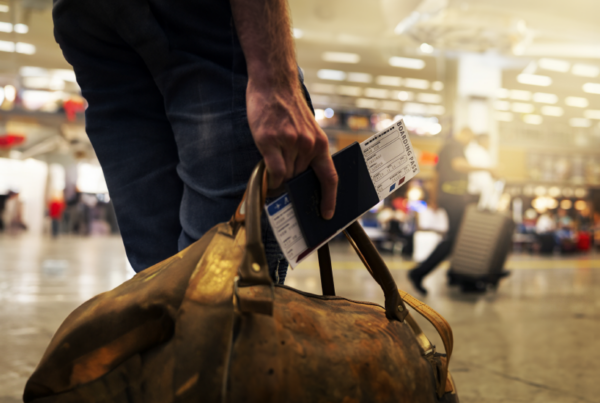 Person holding a suitcase and boarding pass during Christmas holiday season.