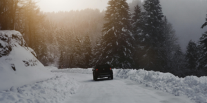 Winter time travel. Car driving on a snowy road.