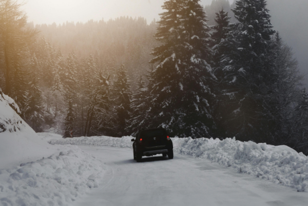 Winter time travel. Car driving on a snowy road.