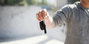 Person handing rental car keys over to traveler during the holidays