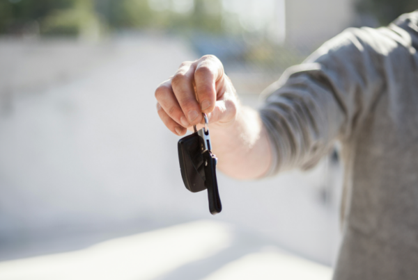 Person handing rental car keys over to traveler during the holidays