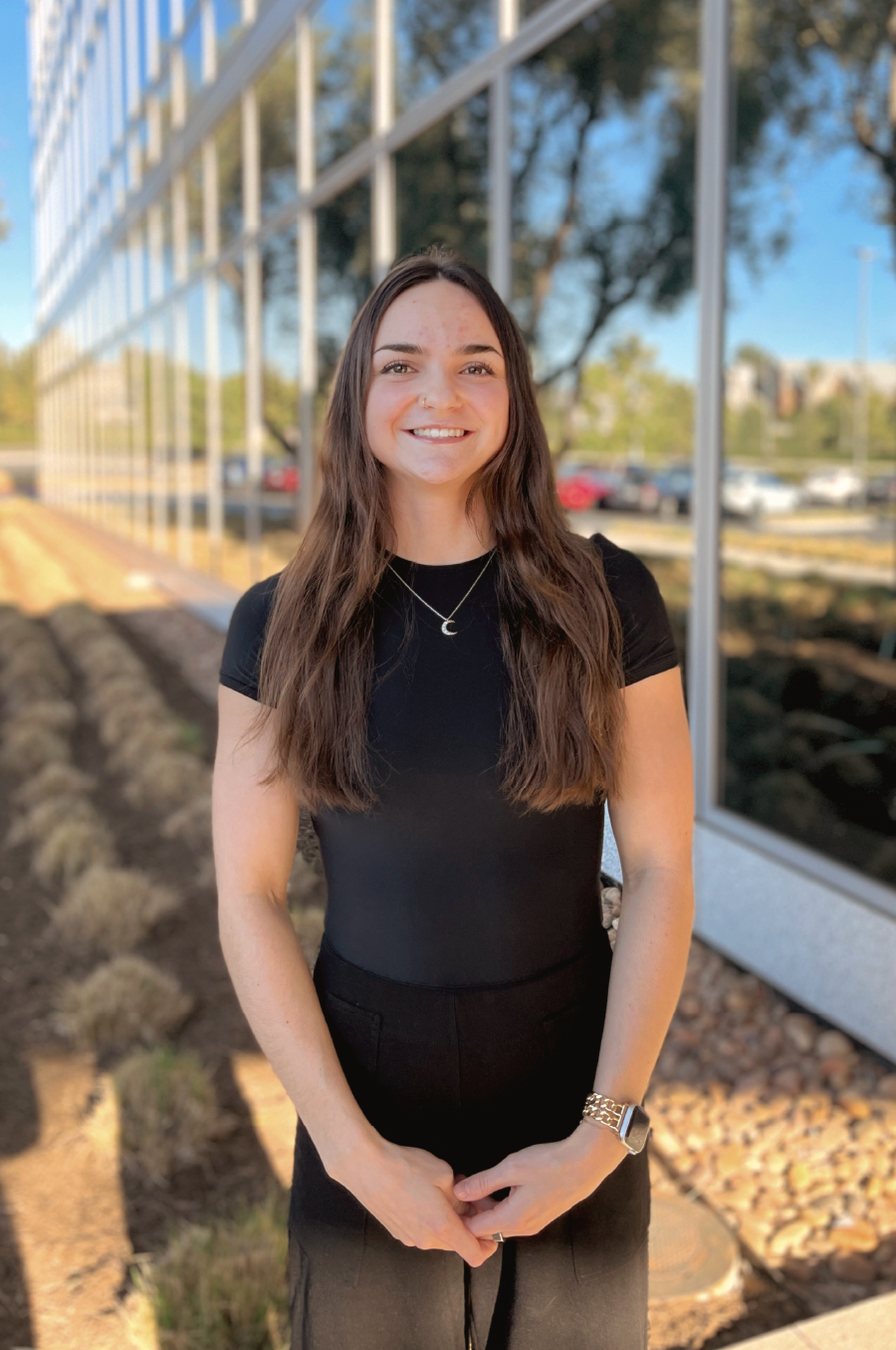 Kelly Ross, Consultation Specialist, standing in front of office building