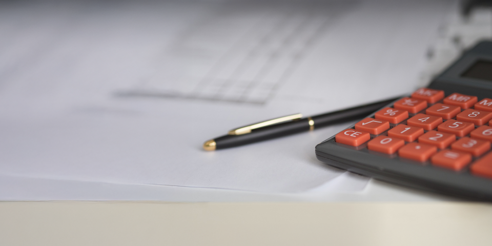 calculator pen and settlement paperwork on a tabletop