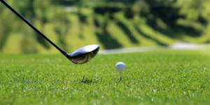 Golf club and golf ball on a tee.