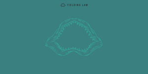 Teal background with Fielding Law shark jaw icon in the middle