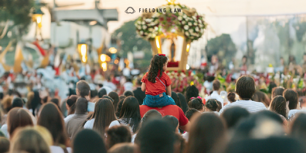 huge crowd of people at an outdoor gathering with a girl sitting on someone's shoulders in the crowd