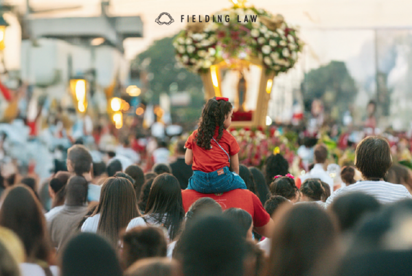 huge crowd of people at an outdoor gathering with a girl sitting on someone's shoulders in the crowd