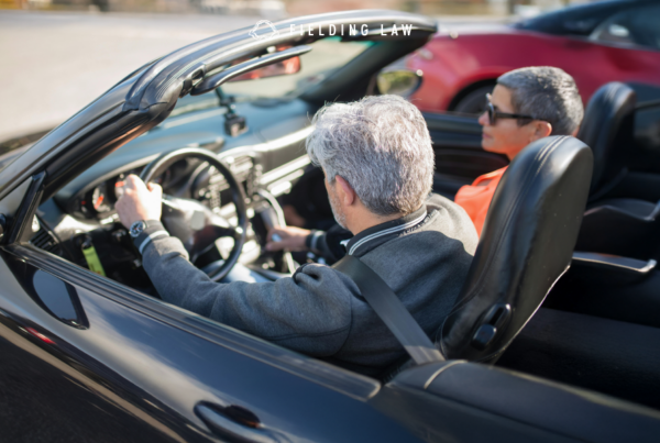 An elderly couple in a convertible car