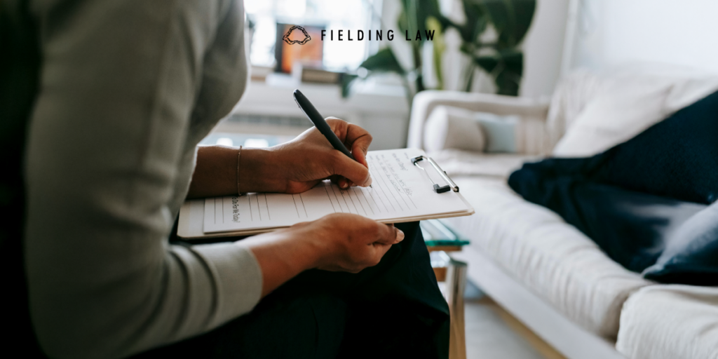 a person sitting in a chair filling out a legal claim check list.