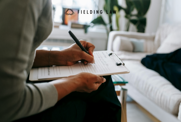 a person sitting in a chair filling out a legal claim check list.