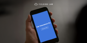 hand holding a phone that reads Car Insurance Co. View Policy