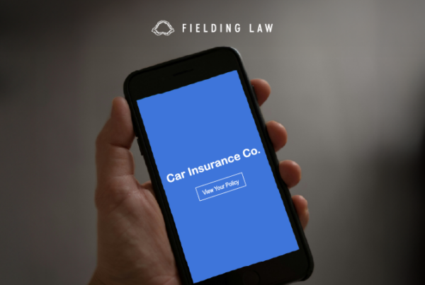 hand holding a phone that reads Car Insurance Co. View Policy
