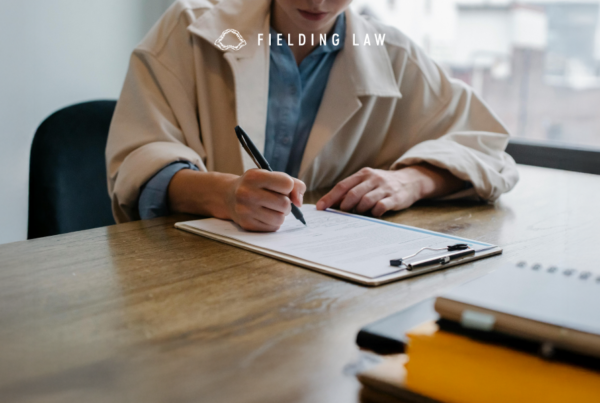 a person sitting at a table writing information from their injury witnesses