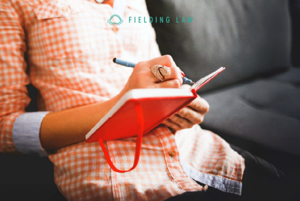 person sitting on a sofa writing in their pain journal