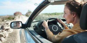 woman driving car down a gravel road
