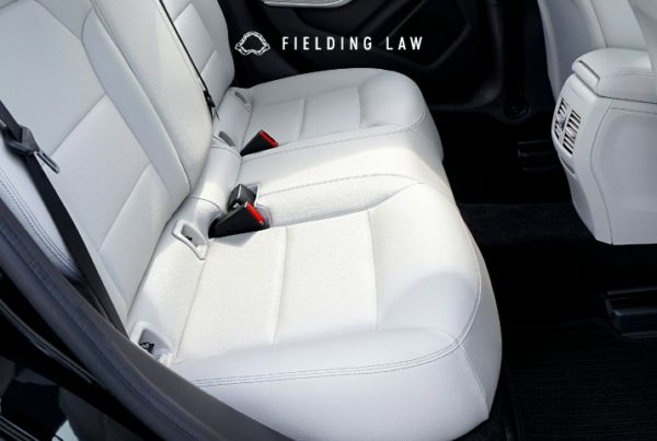 Seatbelt in the back of a car with white seats