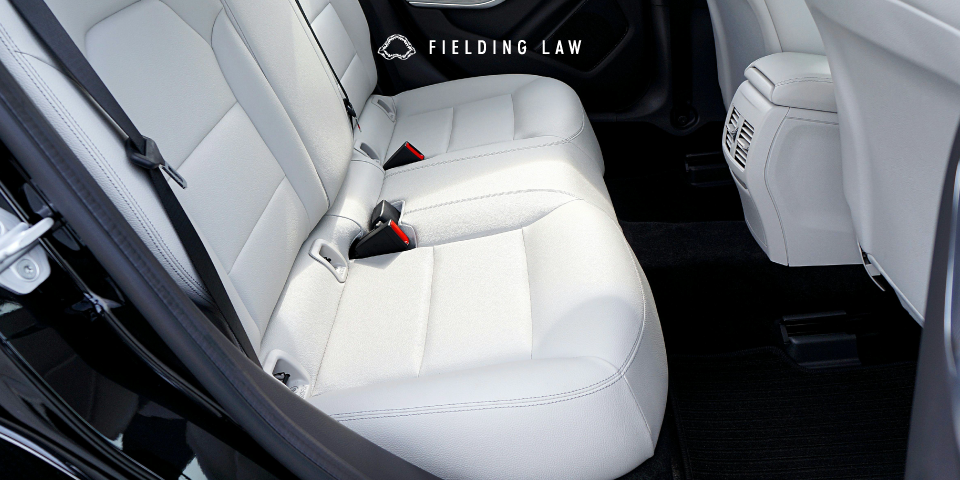 Seatbelt in the back of a car with white seats