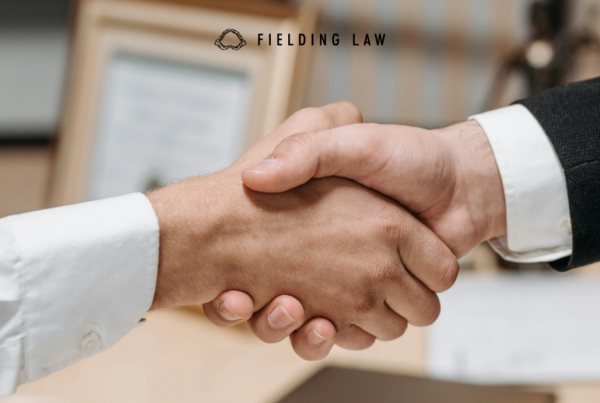 two professionals shaking hands in a law office