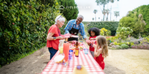 4 people grabbing food at a bbq food table