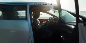 A person in a car touching a phone