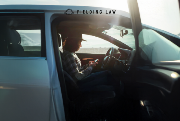 A person in a car touching a phone
