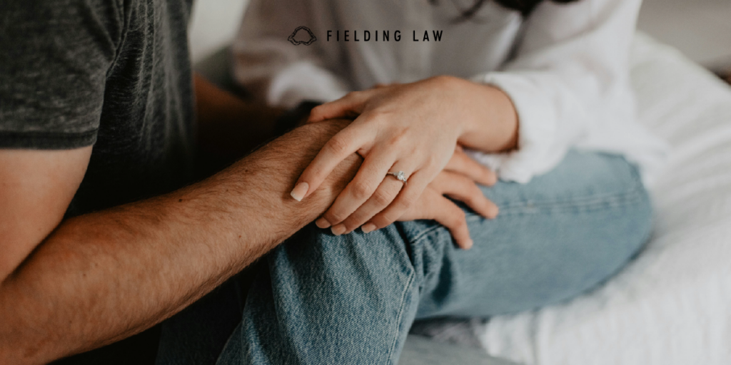 two people holding hands consoling each other after a catastrophic injury