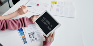 Person holding an Ipad at a desk with paper
