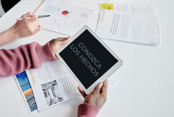 Person holding an Ipad at a desk with paper