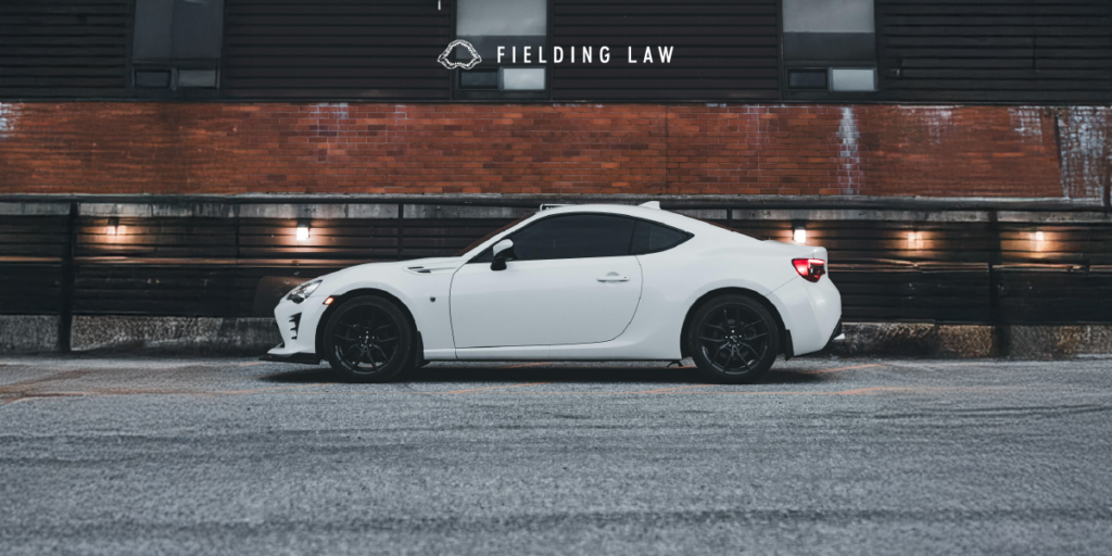 dark tint windows in a white car with a brick wall behind the car