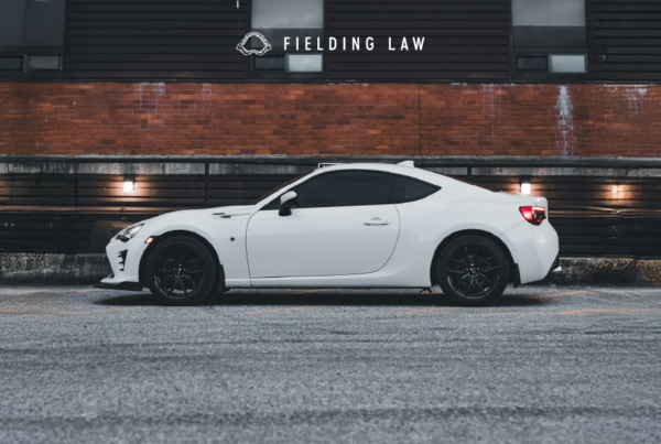 dark tint windows in a white car with a brick wall behind the car