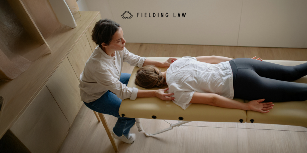 Massage therapist helping align a patient after a spinal injury