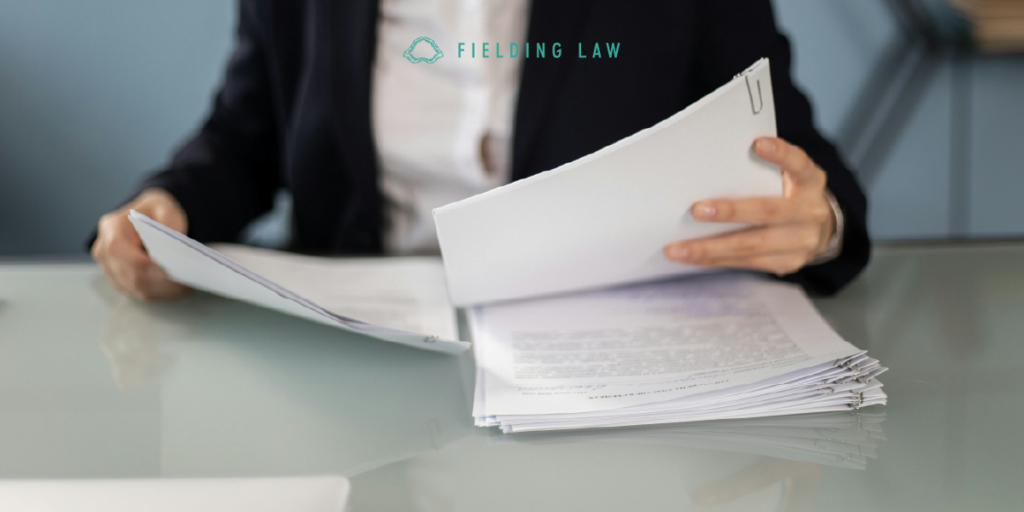 person filing a claim with paperwork on a desk