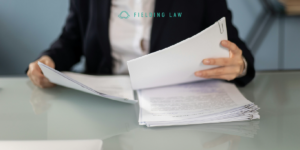 person filing a claim with paperwork on a desk