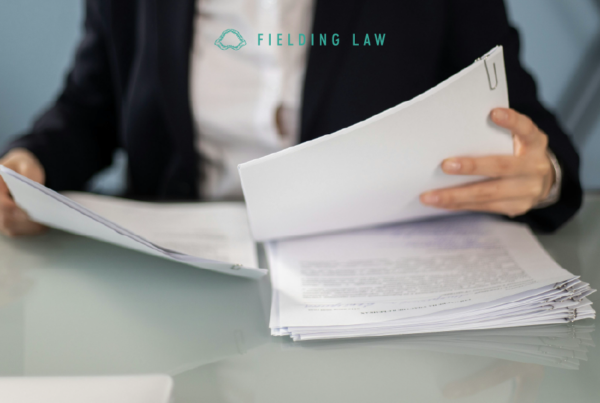 person filing a claim with paperwork on a desk