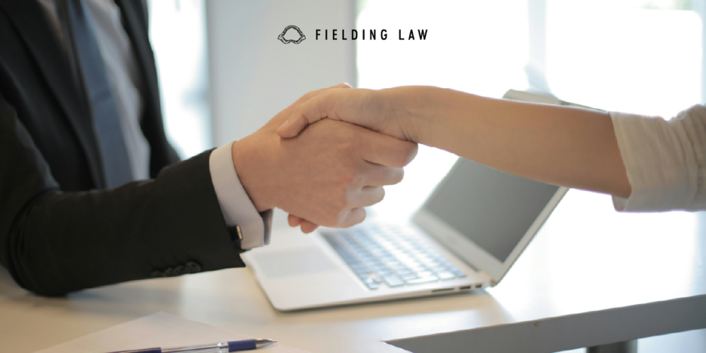 two people shaking hands after a close of an injury case