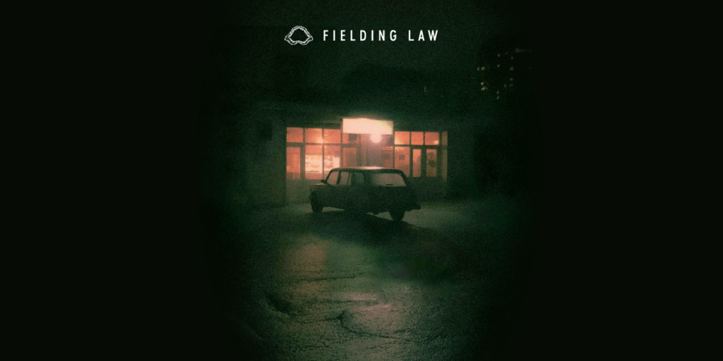 Dark parking lot with negligent lighting and lack of security. It has a creepy feel