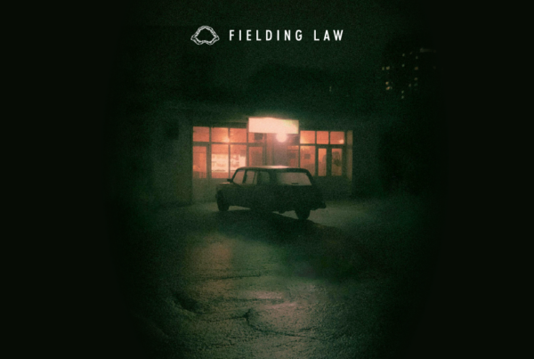 Dark parking lot with negligent lighting and lack of security. It has a creepy feel