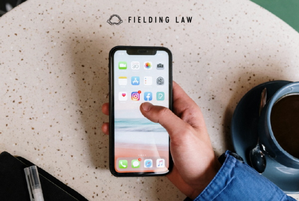 Hand holding a phone at a table with a cup of coffee next to it