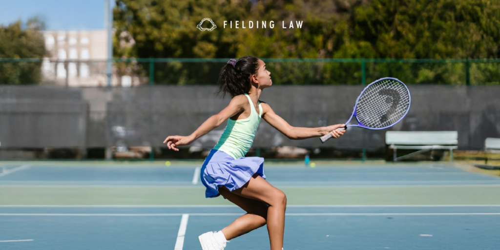 A young girl plays tennis in the summer