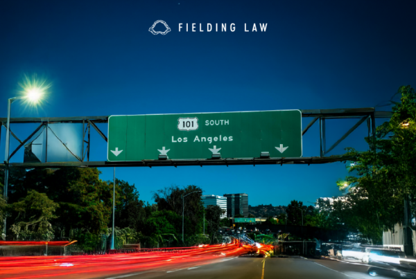 101 Freeway sign at night with cars driving under it