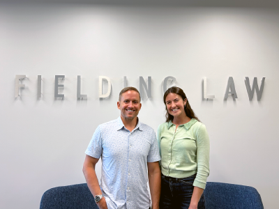 Fielding Law sign on the wall with Clark Fielding and Makenzie Moncrief, Marketing intern